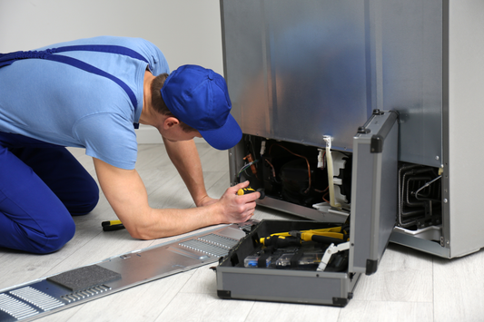 Person working on connecting a waterline for fridge installation. 